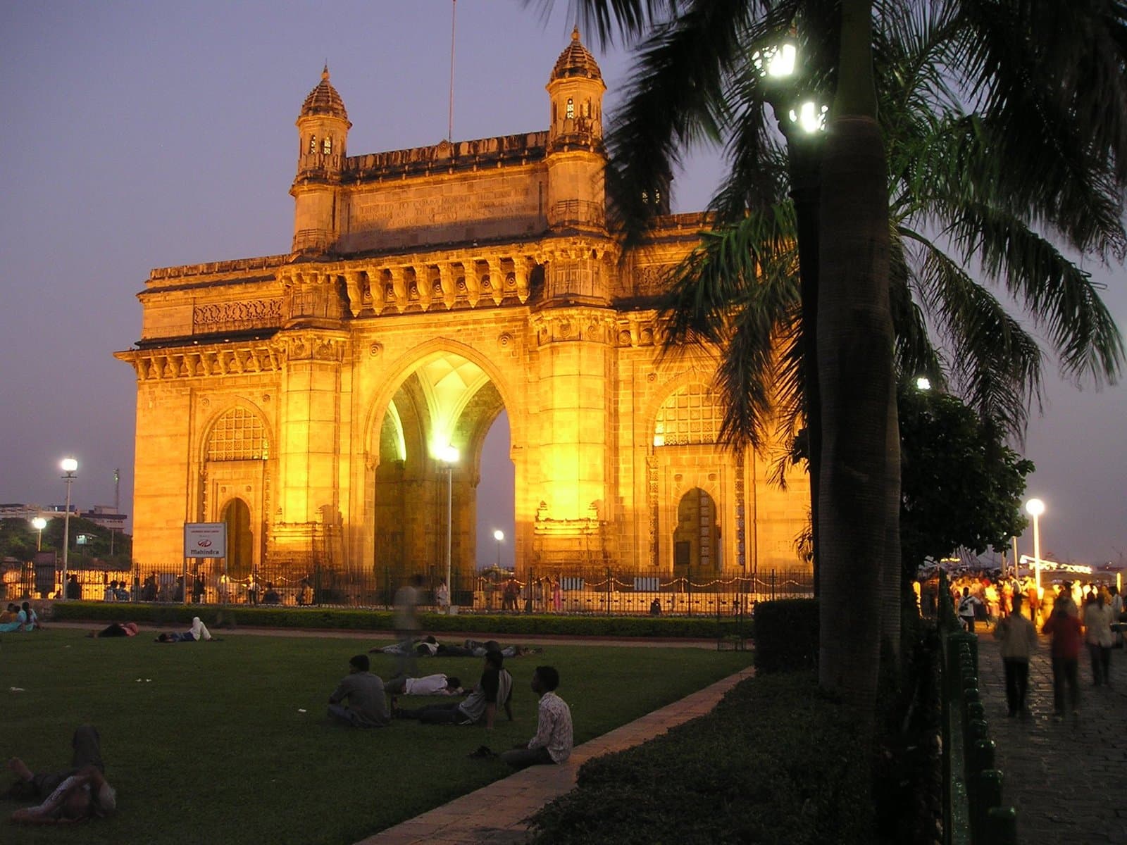 The Gateway of India illuminated in gold at dusk in Mumbai.